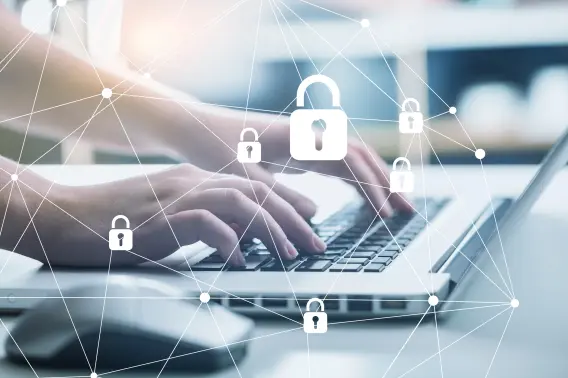 A person types on a laptop, surrounded by digital lock icons, symbolizing cybersecurity and data protection.